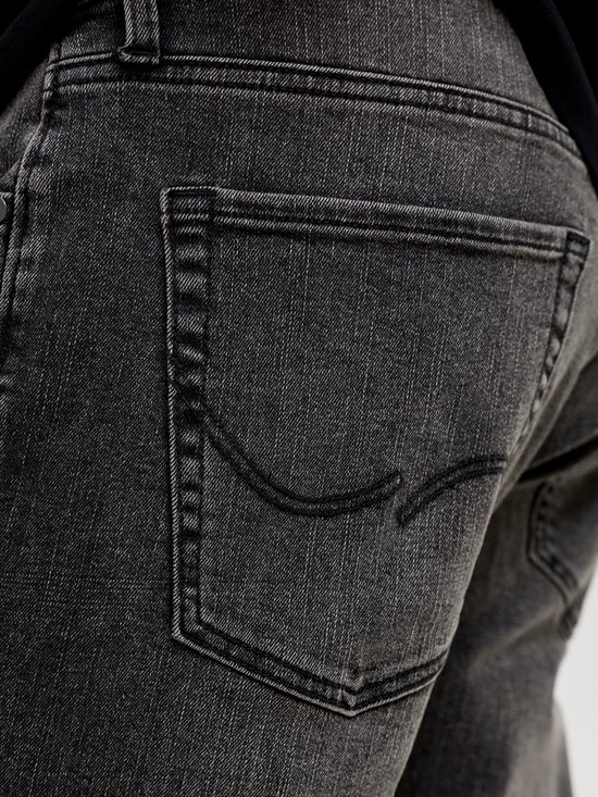 Gedetailleerde achterkant van een grijze jeans met opgestikte zakken en logo.