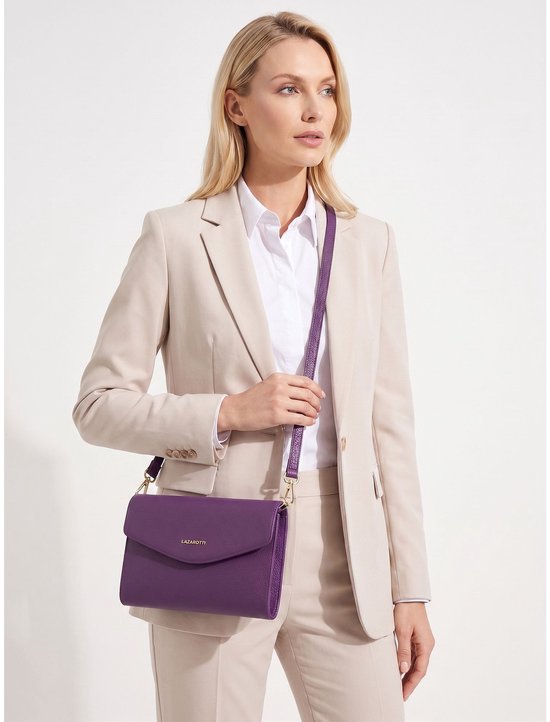 Blonde vrouw met beige blazer draagt paarse crossbody tas met gouden LAZAROTTI logo.