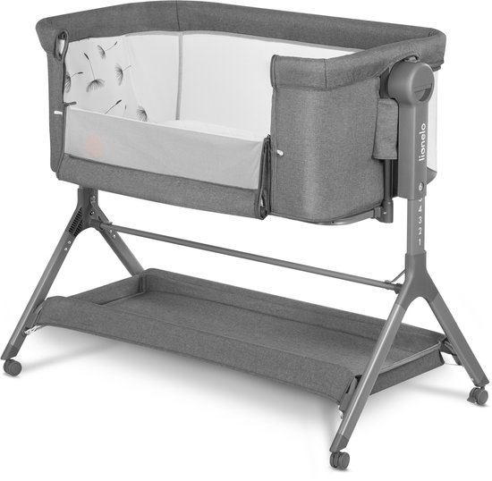 Grijze co-sleeper met een mand onderaan, verstelbare hoogte en een matras met dandelion print.