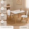 Witte kindertafel met twee witte stoelen. Ronde hoeken en naturel houten poten. Geplaatst op een rond vloerkleed.