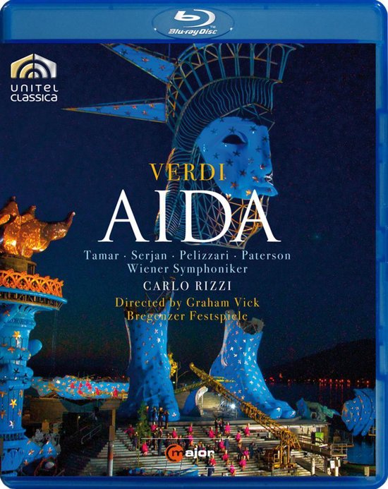 De Blu-ray-hoes voor Giuseppe Verdi's Aida toont een gigantische, blauwe Statue of Liberty-set op een podium, met artiesten op de voorgrond.