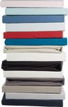 Stapel hoeslakens in diverse kleuren: wit, lichtblauw, blauw, rood, turquoise, beige, zwart, grijs.