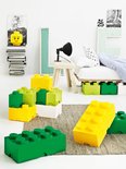 Zomerse slaapkamer met Lego opbergdozen (geel, groen, wit), een bed en decoratie aan de muur.