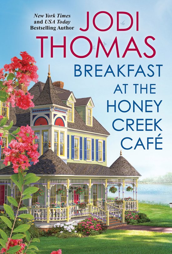 Boek 'Breakfast at the Honey Creek Café' van Jodi Thomas. Een victoriaans huis met een veranda en bloeiende struiken op de voorgrond.