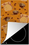 Oranje kookplaatbeschermer met een koffiepatroon, gedeeltelijk op een inductiekookplaat.