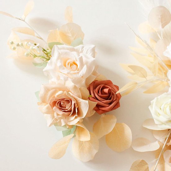 Gedetailleerd bloemstuk met crème, roze en roestkleurige rozen, eucalyptusbladeren en kleine witte bloemetjes.