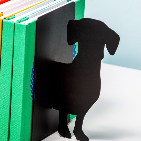 Zwarte teckel boekensteun die een rij groene boeken ondersteunt.