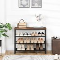 Schoenenrek met 3 etages in een hal, met een bruin houten blad en zwart metalen frame. Er staan diverse schoenen en een tas op.