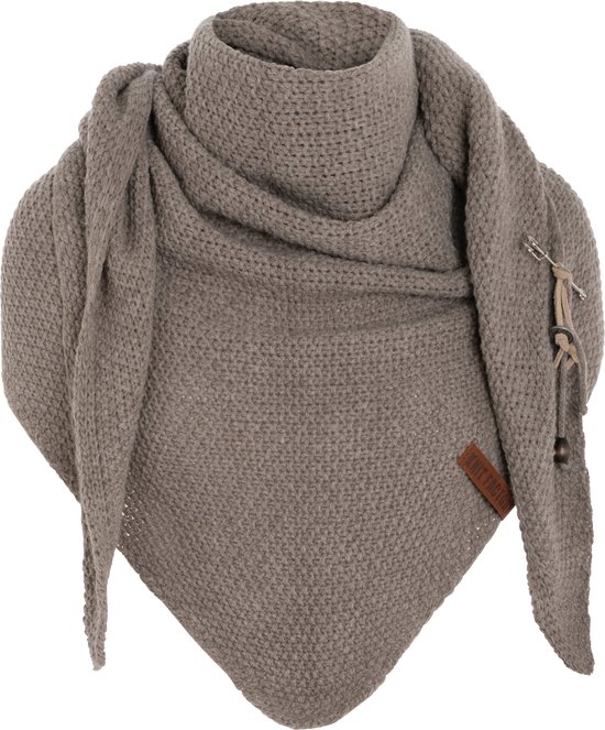 Olijfgroene gebreide omslagdoek met bruin leren label gedragen door een vrouw.