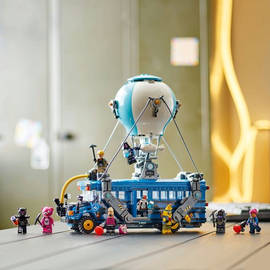 Bus de combat LEGO avec ballon et figurines, sur une table.
