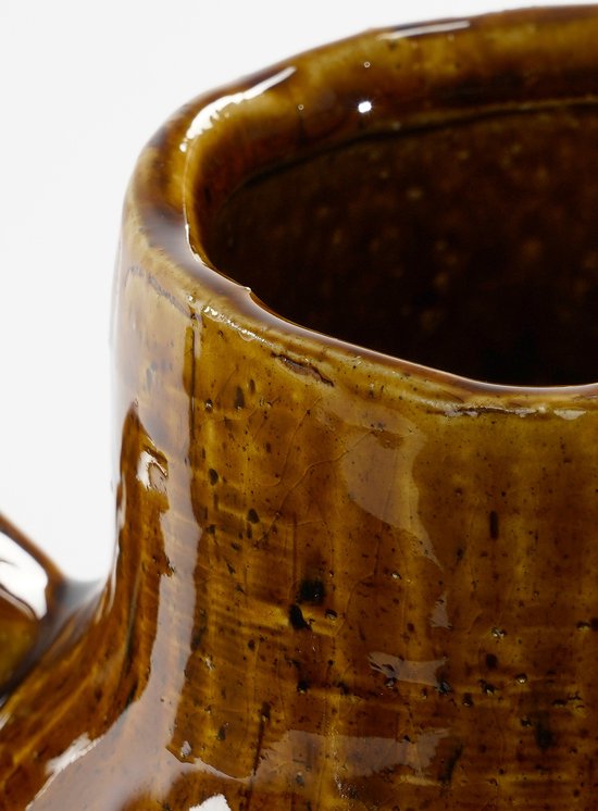 Close-up van de glanzende, gebarsten, bruine keramische vaas met een handvat.