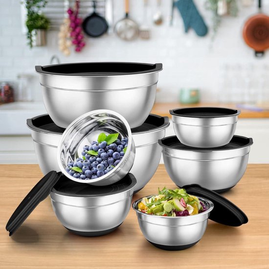 Ensemble de bols mélangeurs en acier inoxydable avec couvercles noirs, sur un plan de travail en bois. Un bol contient des myrtilles, un autre une salade.
