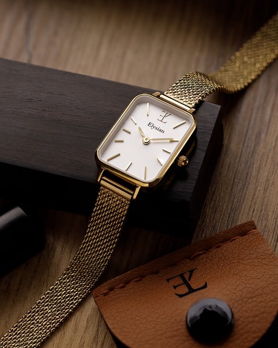 Gouden rechthoekig horloge met mesh band op een houten ondergrond, met accessoires.