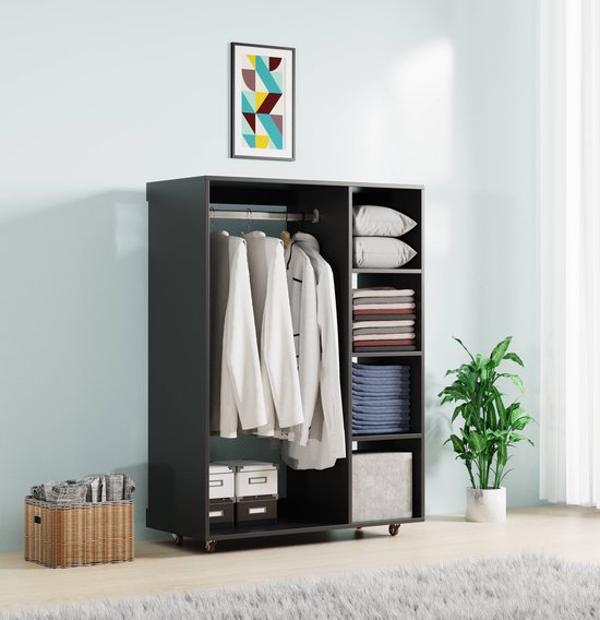 Zwarte kledingkast met hanggedeelte, gevulde planken, opbergdozen, mand met kleding en planten, boven de kast hangt een abstract schilderij.