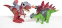 Twee speelgoed dinosaurussen, een rode T-Rex en een groene Stegosaurus, staan tegenover elkaar.