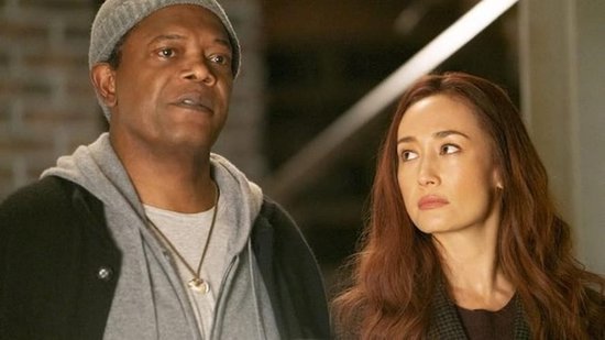 Close-up van Samuel L. Jackson met grijze muts en Maggie Q met rode lokken.