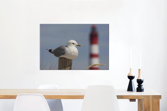 Goéland cendré assis devant un phare Toile 60x40 cm - Tirage photo sur toile (Décoration murale salon / chambre)