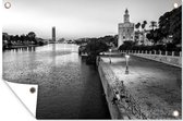 Tuindecoratie De rivier de Guadalquivir in Sevilla en de Torre del Oro in de schemering - zwart wit - 60x40 cm - Tuinposter - Tuindoek - Buitenposter