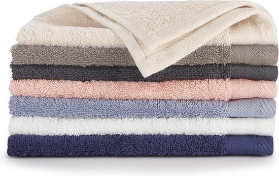 Stapel zachte handdoeken in verschillende kleuren: crème, grijs, antraciet, roze, blauw, wit en donkerblauw.