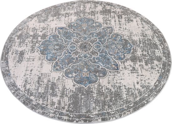 Tapis rond gris avec un motif floral bleu et gris détaillé, d'aspect vintage, au centre et une texture usée.