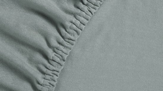 Lichtgrijs jersey split-topper hoeslaken, close-up van de elastische rand.