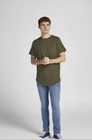 Man met olijfgroen t-shirt met kleine zwarte logoprint en jeans.