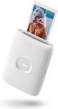 Witte Instax Mini Link 2 printer met een Instax foto eruit printend, met op de foto een persoon die naar de camera lacht.