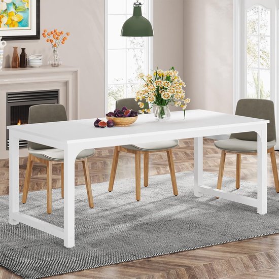 Table de salle à manger blanche avec 4 chaises grises sur pieds en bois, dans un salon avec cheminée.