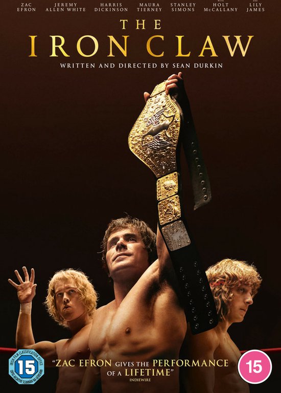 Hoes van de DVD van The Iron Claw met drie worstelaars. De voorste worstelaar houdt een kampioenschapsriem omhoog. Zac Efron geeft 'de performance van een leven'.
