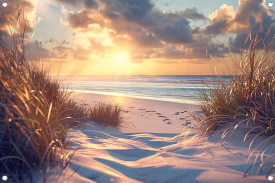 Zonsondergang boven de duinen, strand en zee. Voetsporen in het zand.