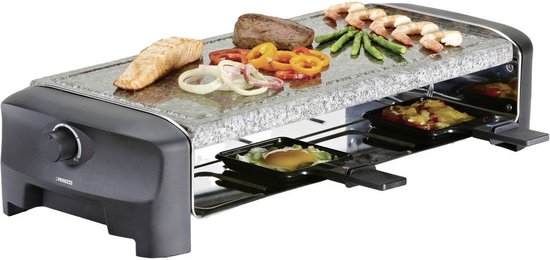 Raclette-grill met gegrilde zalm, steak, garnalen en groenten op de granieten plaat.
