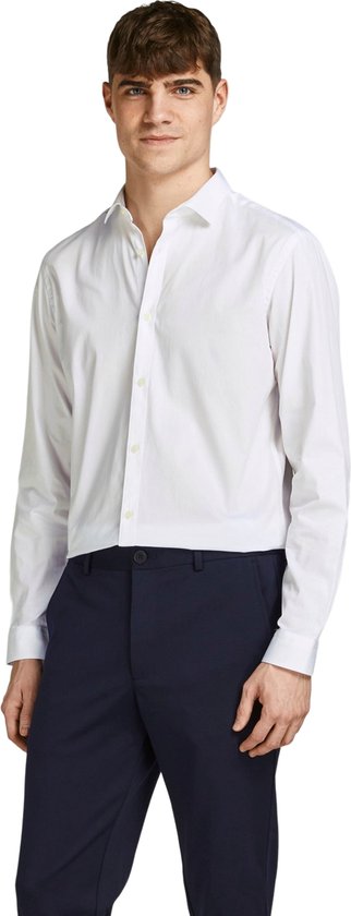 Man met wit slim fit overhemd en marineblauwe broek.