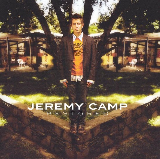 Jeremy Camp met oranje shirt met tekst en blazer.