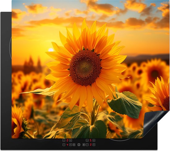 Een inductiebeschermer met zonnebloemen en zonsondergang bovenop een inductiekookplaat.