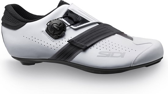 Witte fietsschoen met zwarte gesp, klittenband en perforaties.