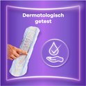 Witte inlegger met paarse bloemenmotief, met blauwe vloeistof en vinkje erop. Dermatologisch getest.