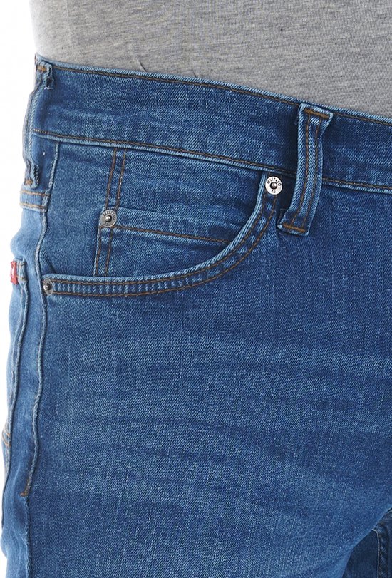 Detail van blauwe spijkerbroek met een klein muntzakje en koperkleurige knoop.
