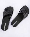 Paar zwarte Ipanema slippers met gevlochten bandjes en logo.