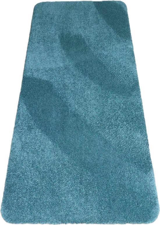 Een turquoise badmat met gebogen hoeken en een subtiel gestreept patroon, op een witte achtergrond.
