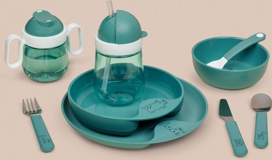 Groen kinderservies met dierenmotieven: drinkbeker met rietje, bord met vakken, kom met lepel, en bestekset met vork en mes.