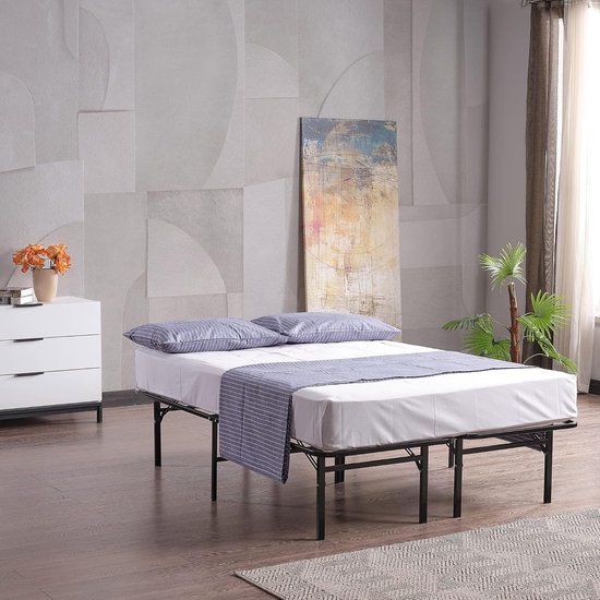 Zwart metalen bedframe met twee matraskussens en een gestreepte deken.