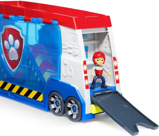 Ryder staat op de laadklep van de PAW Patrol Patroller. De truck is rood, wit en blauw met een blauw transparant deel.
