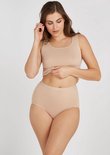 Een vrouw met een plus-size figuur draagt een beige high-waist slip en een bijpassende crop top.