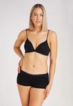 Model met een zwarte kanten bh met dunne bandjes en zwarte shorts.