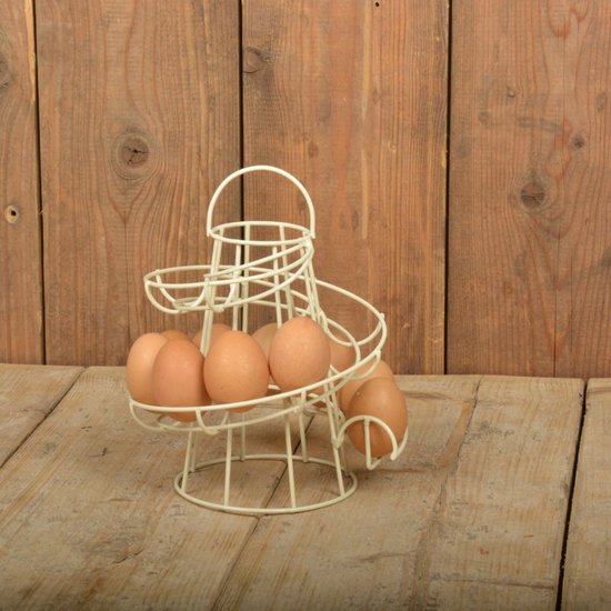 Crèmekleurig metalen spiraal eierrek met 7 bruine eieren, op houten ondergrond voor houten schot.