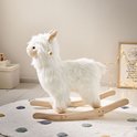 Wit Alpaca hobbelpaard op een rond vloerkleed met stippen, met houten handvatten.