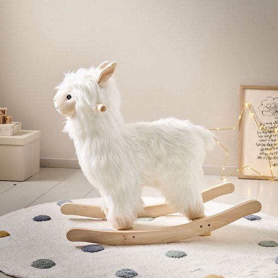 Wit Alpaca hobbelpaard op een rond vloerkleed met stippen, met houten handvatten.