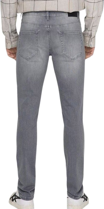 Model staand, de achterkant van een grijze slim fit spijkerbroek.