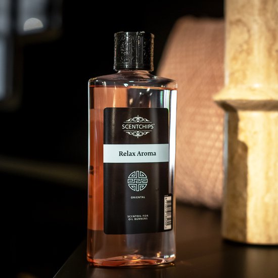 Een fles Scentchips 'Relax Aroma' met een oranjegekleurde vloeistof en een zwart label.