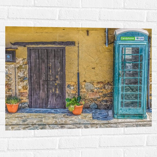 WallClassics - Muursticker - Gele Muur met een Blauwe Telefooncel - 80x60 cm Foto op Muursticker